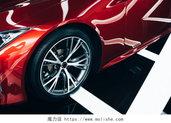 一辆红色的汽车的轮毂和外扩闪亮的新红色汽车与金属车轮在汽车陈列室 